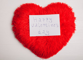 Decorations for Valentine's Day. heart pillow and letter on wooden background