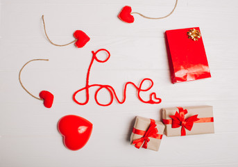 decorations for Valentine's Day. gifts, heart and the words "Love" on white wooden background