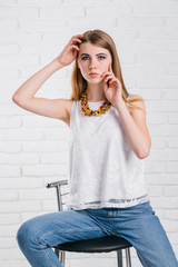 Pretty young sexy fashion sensual woman posing on white wall background dressed in hipster style jeans outfit,Stylish fashionable blonde girl  in black clothes. ,not isolated