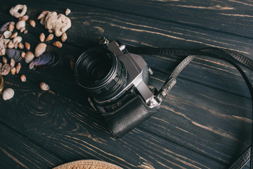 travel background. Men's style hat, compass, seaShell and camera on a wooden background