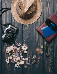 Travel background. Men's style clock, flashlight, documents, hat, compass, money, phone and camera on a wooden background