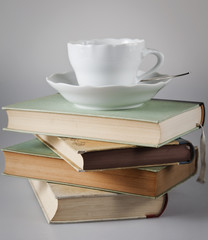 Naklejka premium Kaffeetasse auf Bücherstapel