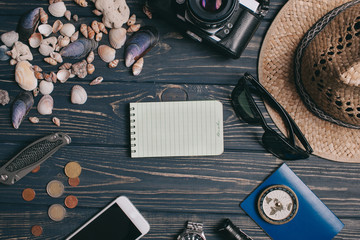 Travel background. Men's style clock, flashlight, documents, hat, compass, money, phone and camera on a wooden background