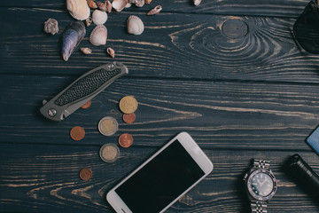 Travel background. Men's style clock, flashlight, documents, hat, compass, money, phone and camera on a wooden background