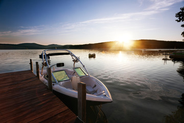 Boat docked on a calm Merrymeeting Lake in morning light