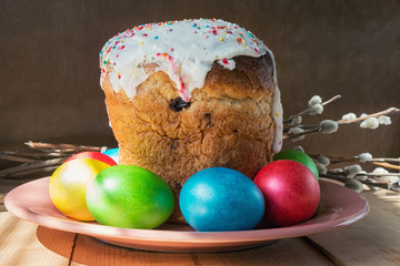 Easter cake and painted eggs on wooden table