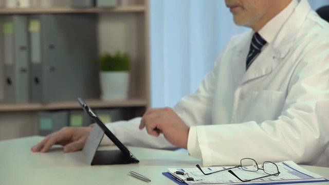 Doctor viewing patients x-rays on tablet in hospital, modern technologies