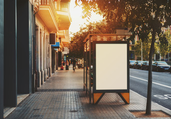 City bus stop with empty mock up banner for your advertising, blank billboard with copy space area for your text message or promotional content, public information board in urban setting - obrazy, fototapety, plakaty