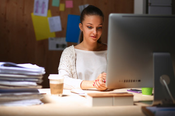 Young woman working in office, sitting at desk