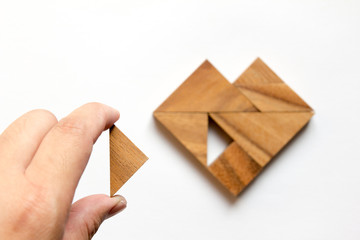 Man held piece of tangram puzzle to fulfill the heart shape on w