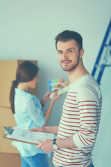 Couple choosing paint colour from swatch for new home