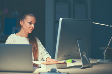 Young woman working in office, sitting at desk