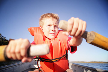 Boy rowing a boat on a lake. Instagram effect