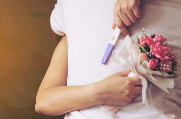  woman with pregnancy test hugging man