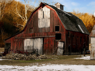 An abandoned old red barn in the country.