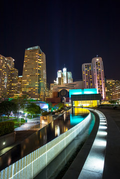 Skyscrapers in San Francisco at night.  Reflections on the water in a pond.