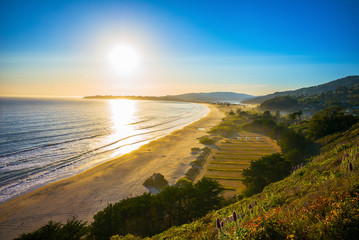 Sunset over Stinson Beach just north of San Francisco, California, USA.  Spring flowers in the foreground. - 134173090