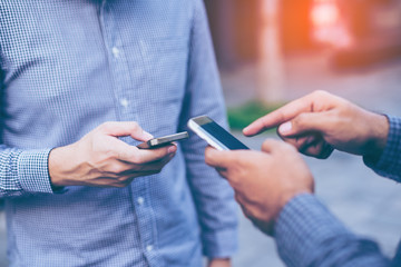 Hand of group businessman using while reading his smartphone