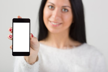 Businesswoman holding smartphone in hand. Gray background