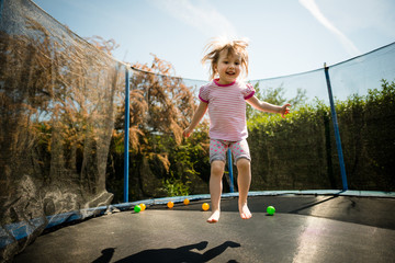 Child jumping trampoline - obrazy, fototapety, plakaty