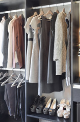 modern closet with row of black dress and shoes in wardrobe.