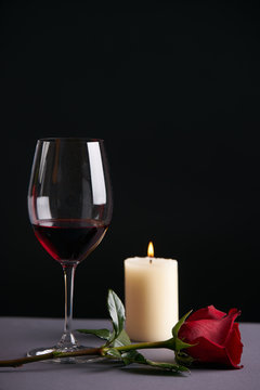 Wineglasse with red rose and candle  on a dark background. Valentine's day theme concept