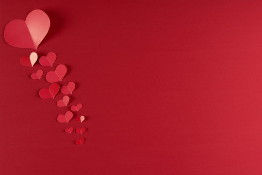 Red hearts on a red background. Love card concept with copy space, Valentine's day theme. Shot from above