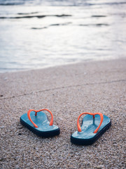 Fototapeta na wymiar Colorful flip flops on the sandy beach