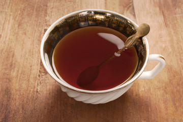 Vintage tea cup with spoon on wooden table
