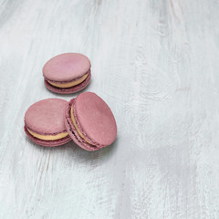 Pink macarons on pale whitewashed board with copyspace