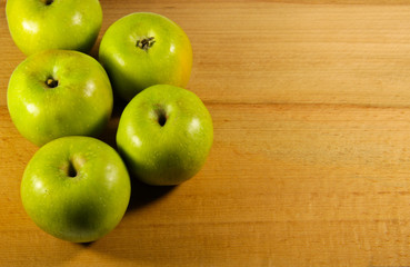 Fresh green apples on wooden background