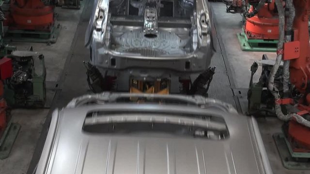 Car factory. Robotic arm machine welding and joining pieces. Making car in working lines