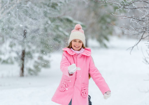 Little girl throws snow up in the air