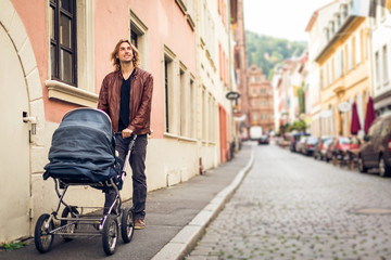 Obraz premium Young Father With Baby Stroller In The City
