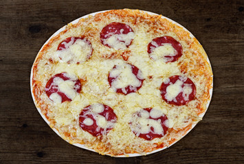 Pizza Salami on dark wooden background