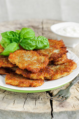 Fried potato pancakes with basil leaves