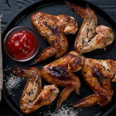 Closeup of bbq chicken wings with black sesame, salt and sauce