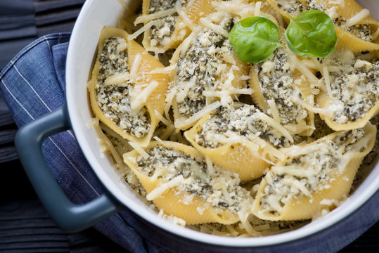 Closeup of italian conchiglioni with cheese and spinach stuffing