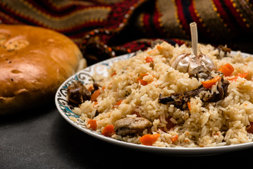 Pilaf on plate with oriental ornament and Traditional Asian breads - churek. Plov.