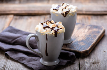 S'mores drink. Two mugs of hot chocolate with marshmallows on a wooden table. Cocoa.