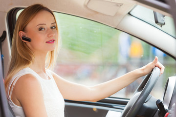 woman driving car with headset