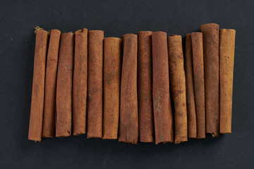 Cinnamon sticks on dark background, top view