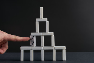 Hand breaking dominoes tower