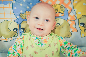 Baby lying in bed and smiling