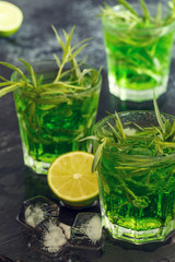 Green cocktail with lime, soda, crushed ice and tarragon leaves.
