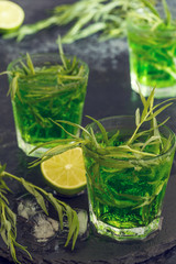 Green cocktail with lime, soda, crushed ice and tarragon leaves.