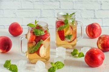 Homemade lemonade with peaches and mint leaves.