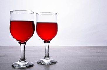 glass of red wine. A couple of glasses of wine on a light wooden background