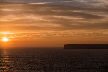 Naklejka na ściany i meble Ocean Sunset with Cliff Silhouette