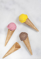 Various ice cream cones are on the marble surface.